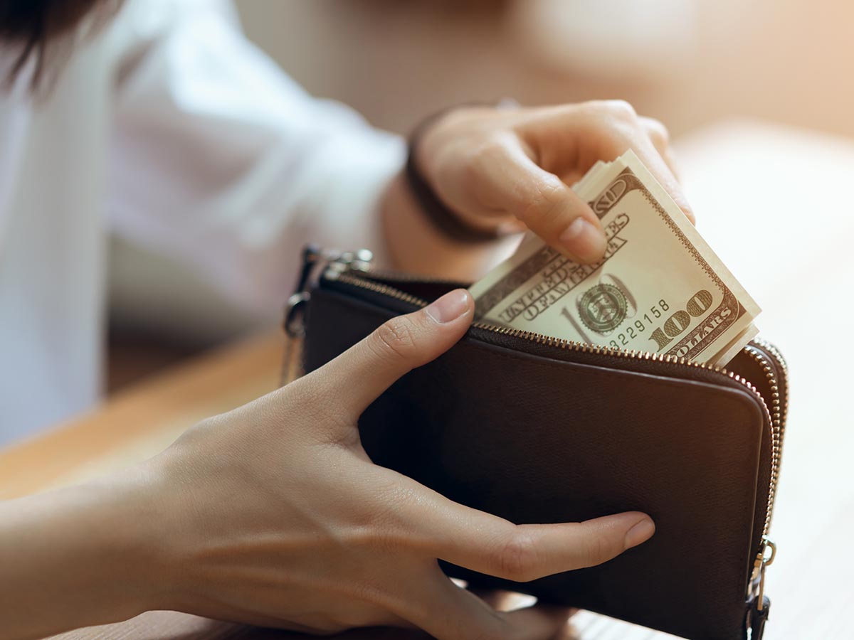 Woman pulling money out of wallet