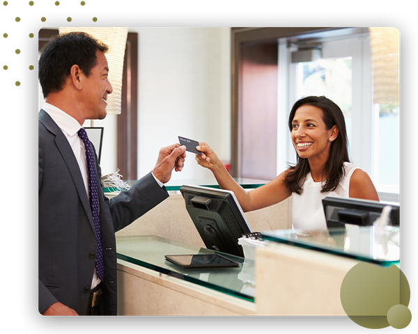 Man checking into hotel with smiling receptionist